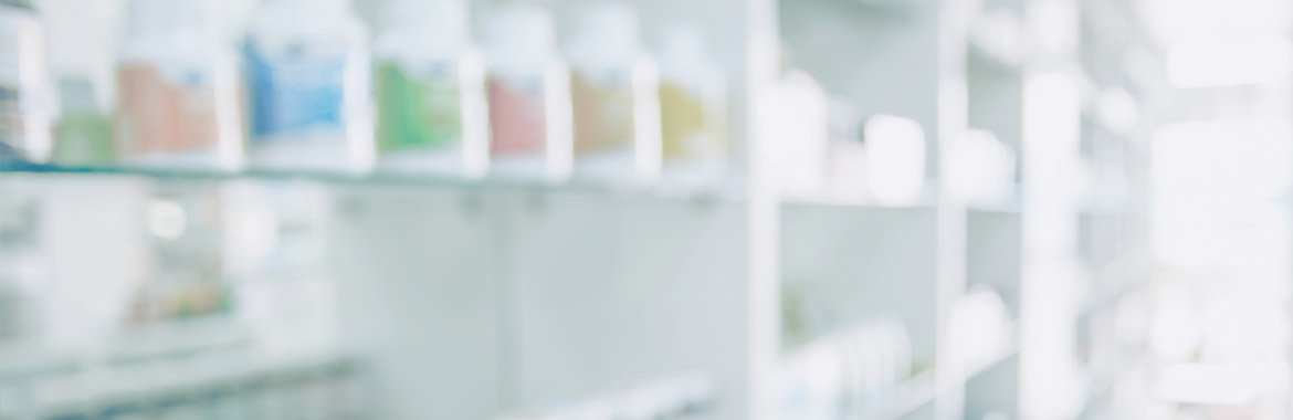Blurred image of medicine bottles on pharmacy shelves.