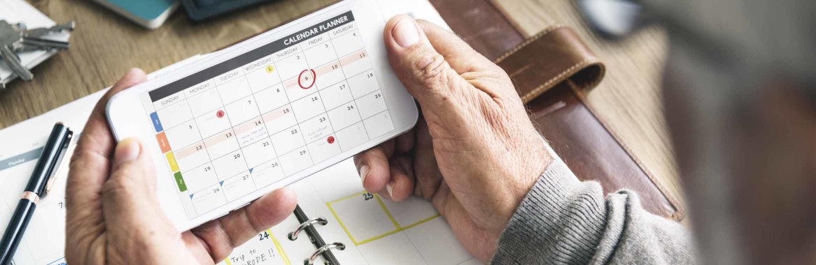 A man takes a look at his calendar to plan things out.