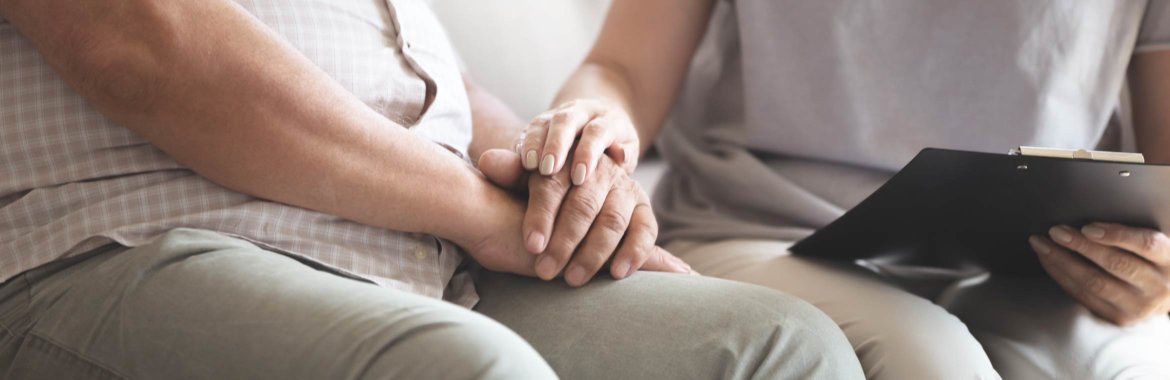 Closeup of a caregiver holding hands with her loved one.