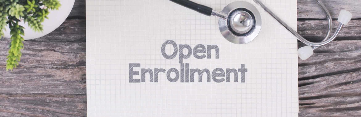 A stethoscope on top of a piece of paper with the words "Open Enrollment" written on it.