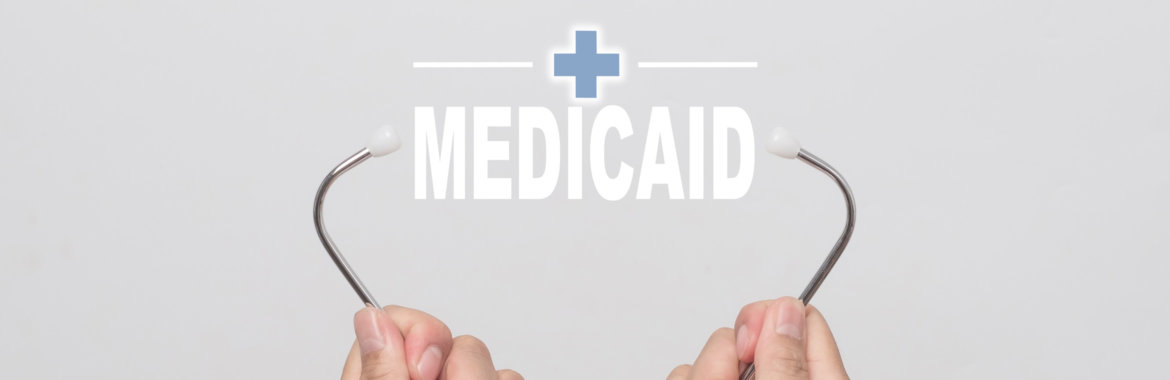 Two hands holding stethoscope around the word "Medicaid."