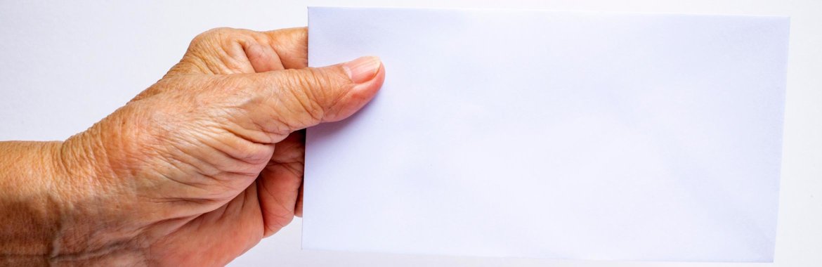 Older woman holds an blank envelope in her hand.