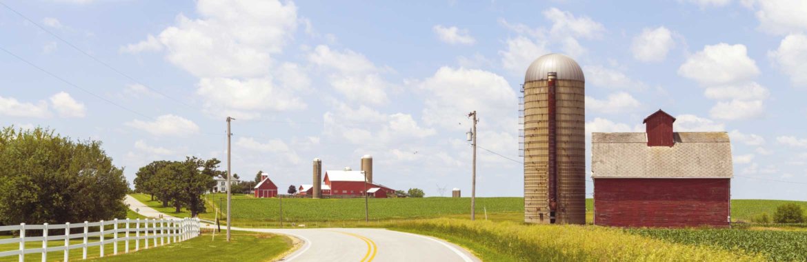 A picturesque farm house and silo sit next to a country road in Illinois.