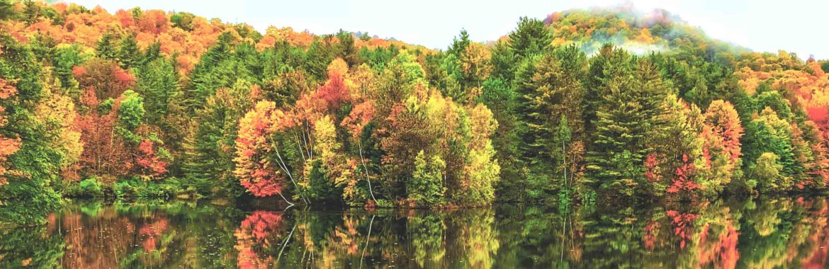 Vermont's colorful fall foliage is reflected in a lake.