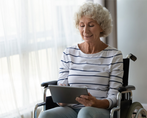 Woman in wheelchair using tablet.
