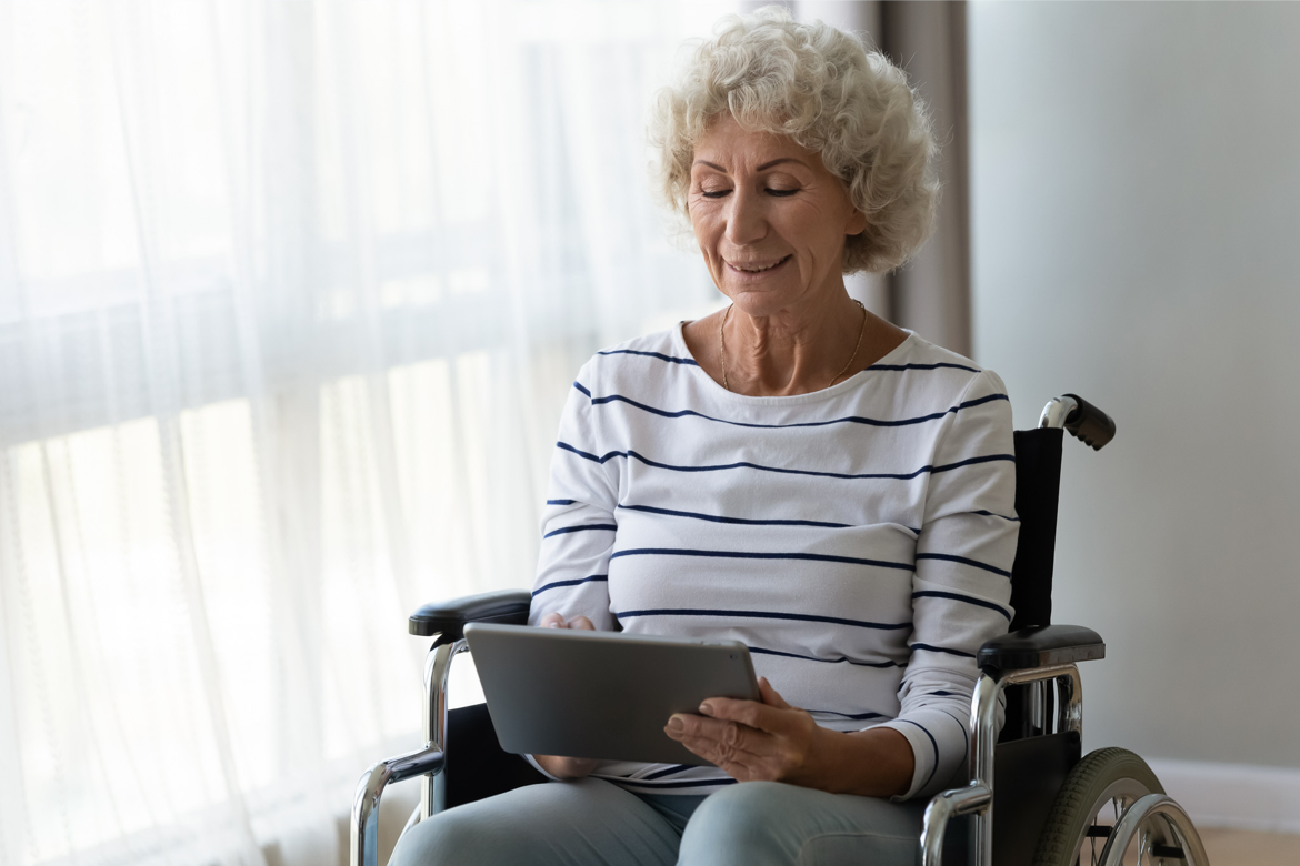 Woman in wheelchair using tablet.