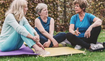 Women on yoga mats talking.