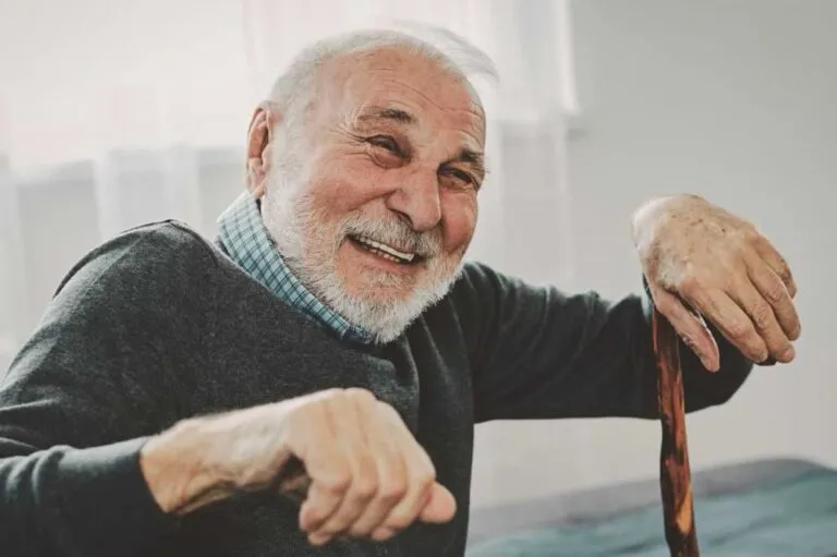 Smiling man with a cane.