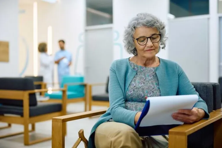 Woman completes paperwork in a waiting room.
