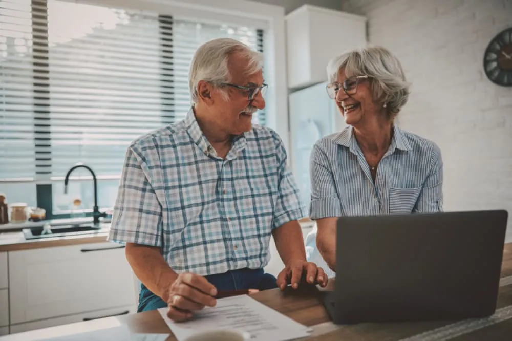Couple laughing at computer.