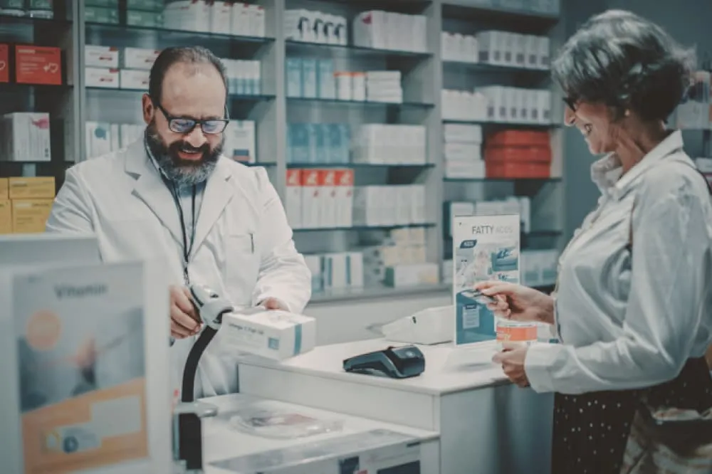 A senior woman is buying medication from a pharmacist