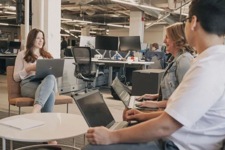 People having a meeting with laptops in an open office space