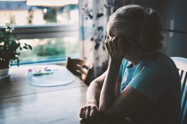 Sad woman sitting at table.