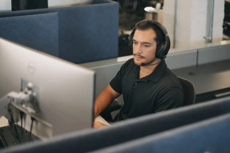 Licensed insurance agent at workstation, wearing headset.