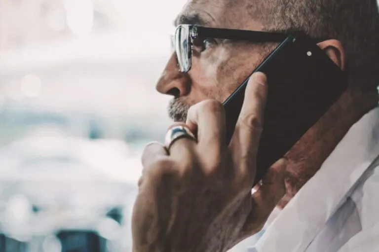 A senior man is making a phone call