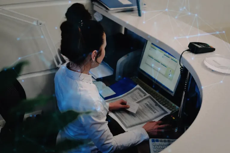 Healthcare worker seated at a computer, entering insurance information.