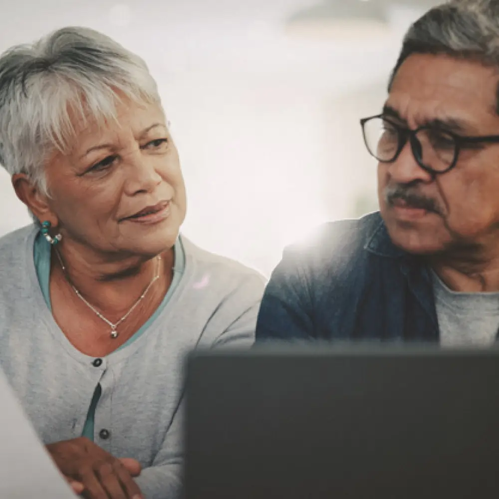 Older couple sitting at a computer, considering their options during the Medicare Annual Enrollment Period.